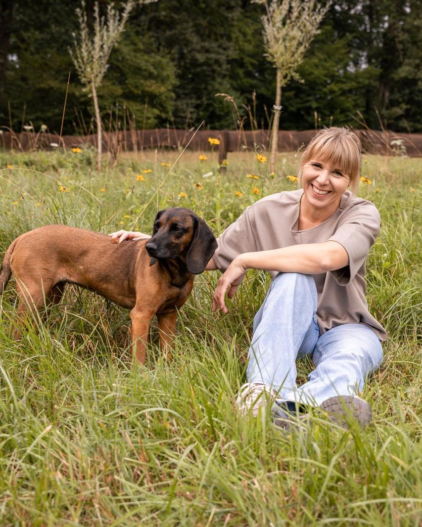 Christina Herout, Gründerin von RESPIRA, mit ihrer Hündin Aike auf der Wiese